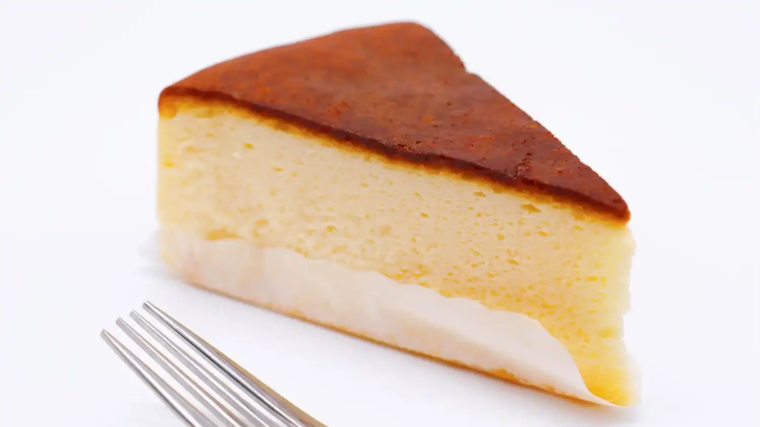 Slice of fluffy Japanese cheesecake with a golden top, a popular Japanese dessert known for its light, airy texture.