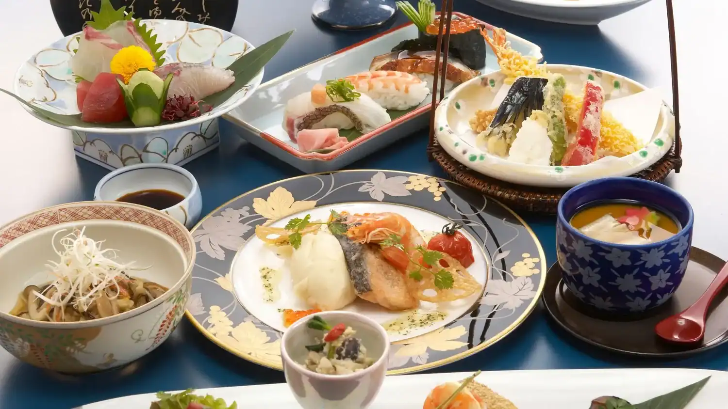 Kaiseki meal in Japan featuring sashimi, tempura, grilled fish, chawanmushi, and seasonal Japanese dishes arranged beautifully on traditional plates.
