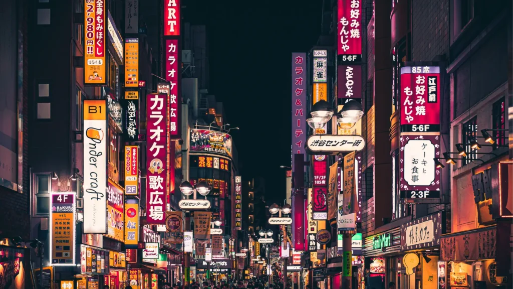 Shinjuku nightlife street with bright signs and crowds, evening things to do in Tokyo