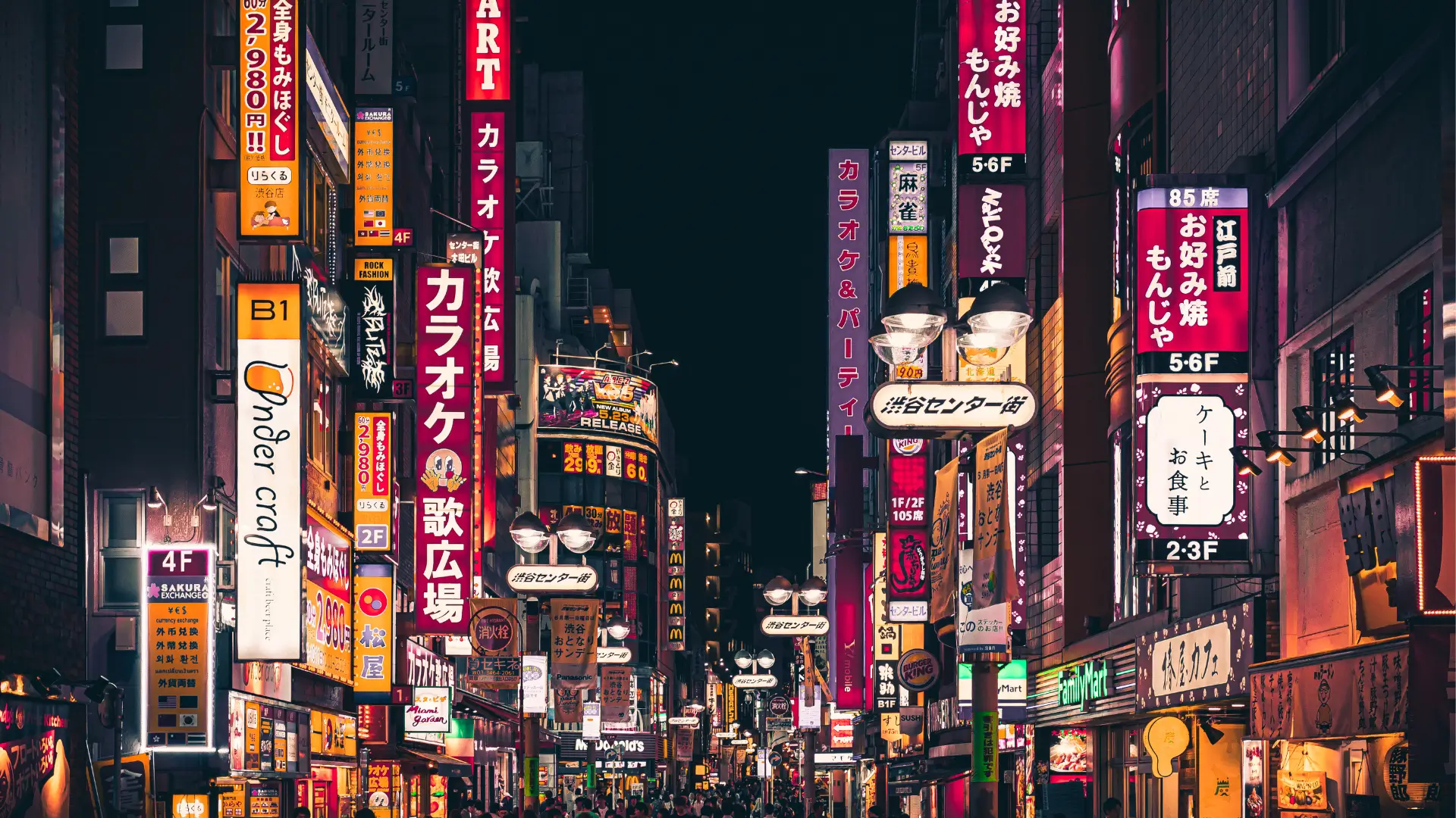 Shinjuku nightlife street with bright signs and crowds, evening things to do in Tokyo