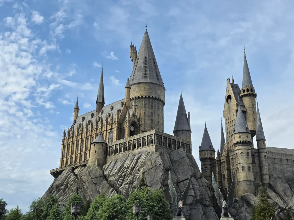 Things to Do in Osaka at Universal Studios Japan featuring Hogwarts Castle rising above rocky cliffs under a blue sky.