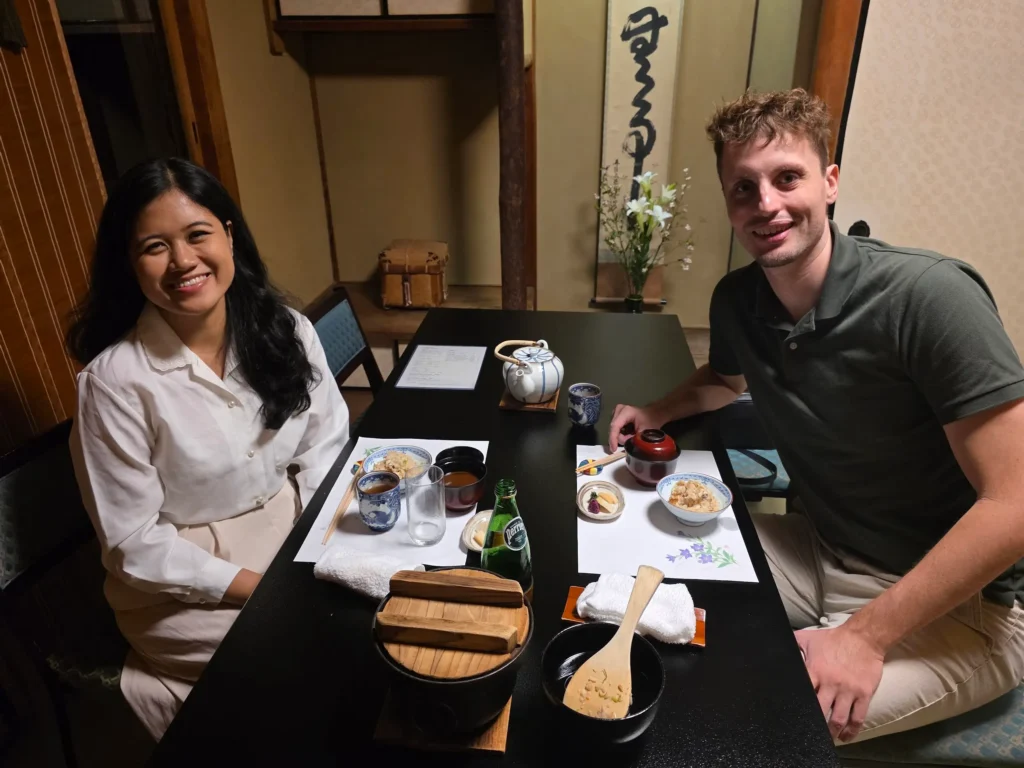 Two travelers seated at a traditional Japanese restaurant table, demonstrating restaurant etiquette in Japan during a tatami-style dining experience. Restaurant Etiquette in Japan