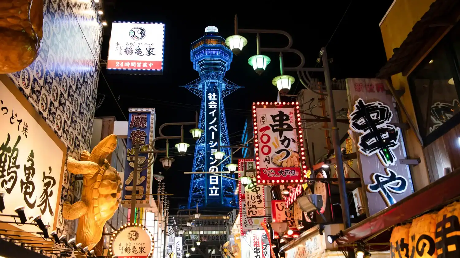 Best street food in Tokyo shown through a neon-lit nighttime food and nightlife area with glowing signs and lanterns