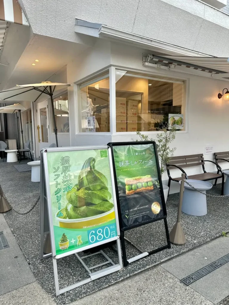 Things to Do in Uji: matcha soft serve ice cream stand with rich green tea desserts displayed outside a tea shop