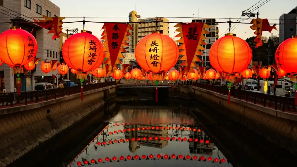 Traditional festivals in Japan shown through lanterns lining a canal during the Nagasaki Lantern Festival at dusk.