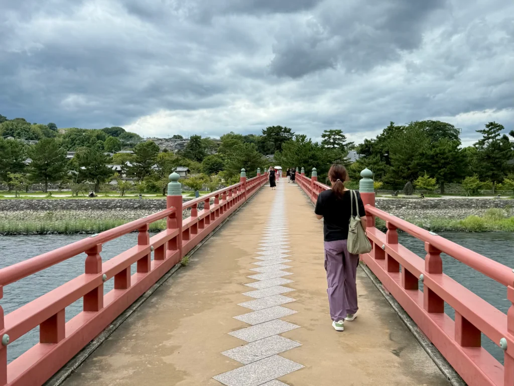 Things to Do in Uji: walking across the red Uji Bridge with views of the river and surrounding greenery