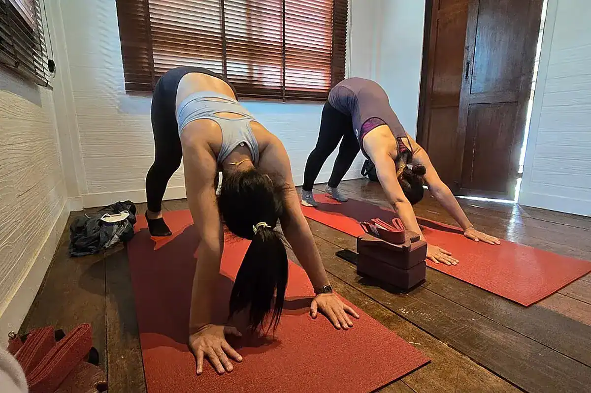 Two women doing yoga poses in Maa Yoga Studio & Spa, one of the best wellness retreats in Thailand.