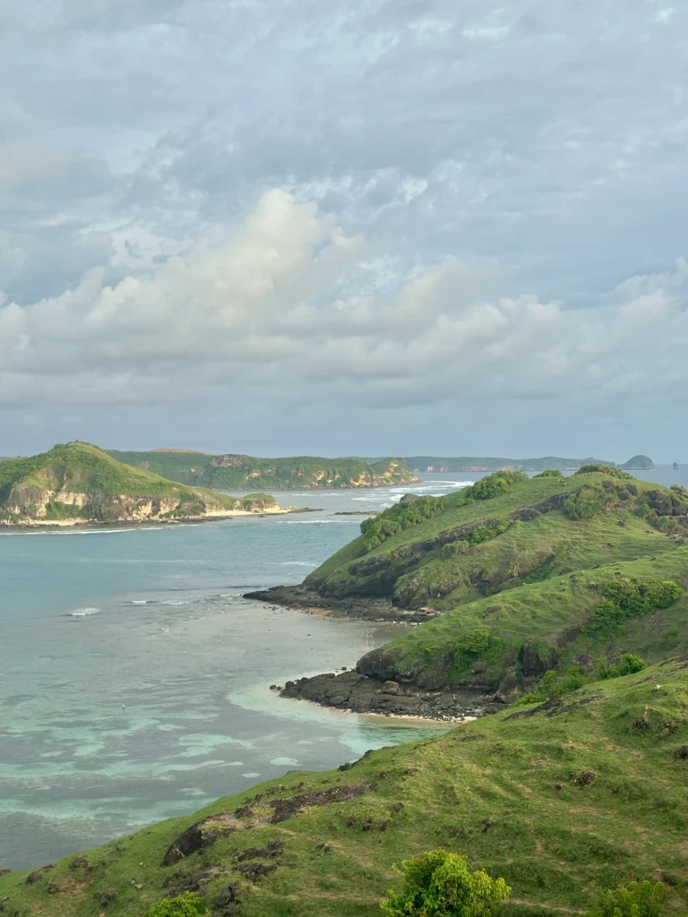Green coastal hills and turquoise water at Bukit Merese, a scenic viewpoint and one of the best things to do in Kuta Lombok