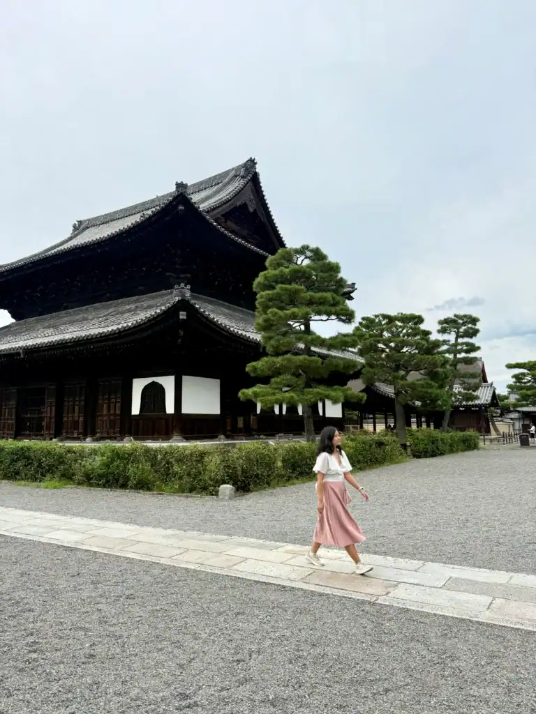Japan packing list outfit featuring a lightweight skirt, sneakers, and breathable top worn while walking through Kyoto temple grounds.