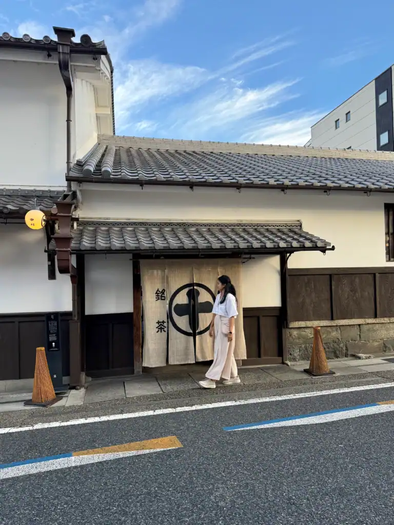Japan packing list outfit with loose trousers, supportive walking shoes, and neutral layers for exploring traditional Kyoto streets.