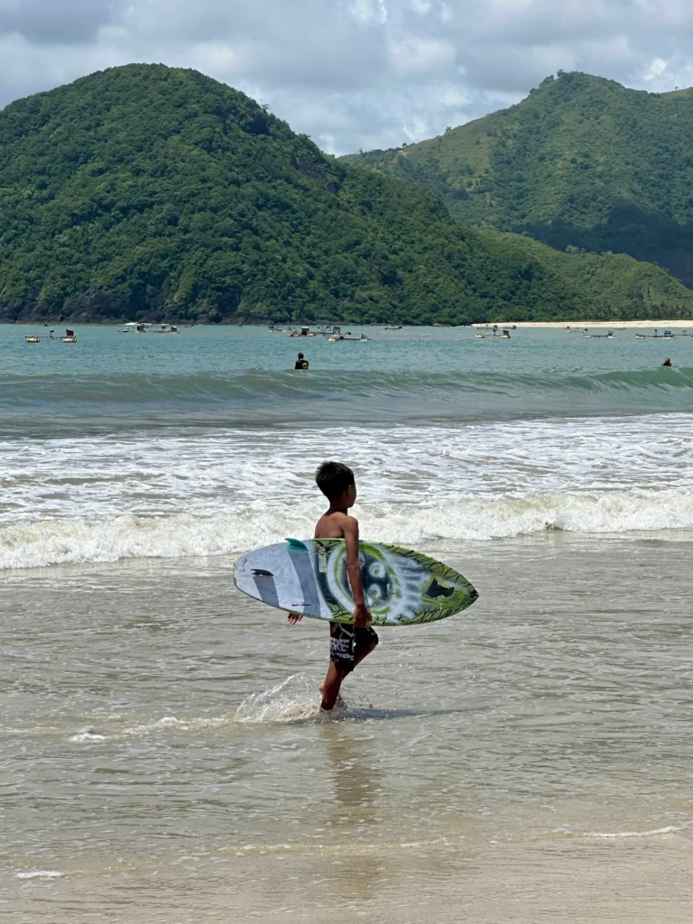 Surfer walking into the water at Selong Belanak Beach near Kuta Lombok, a popular spot and one of the classic things to do in Kuta Lombok
