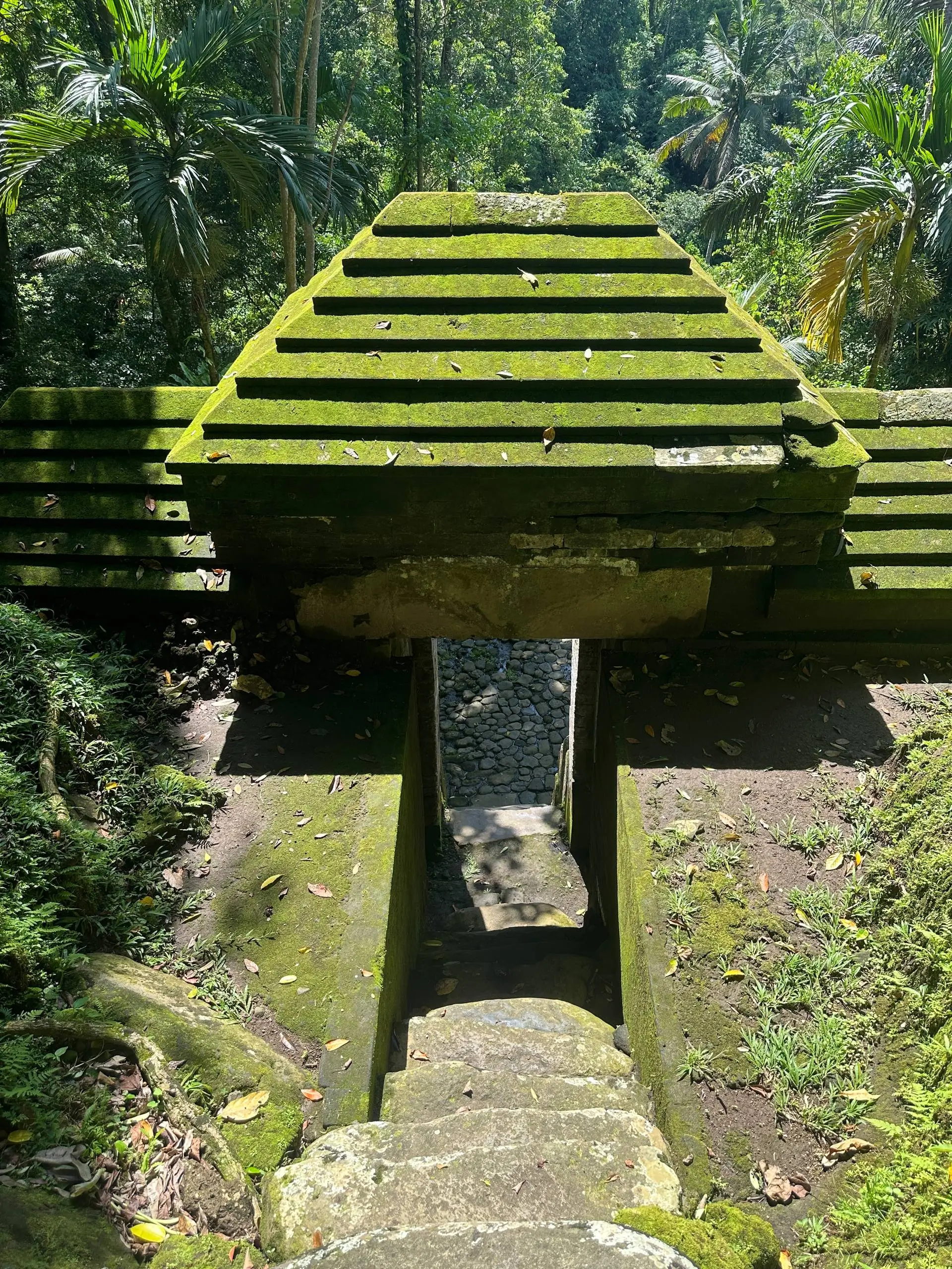 Ancient moss-covered temple structure at Goa Garba in the forest near Ubud