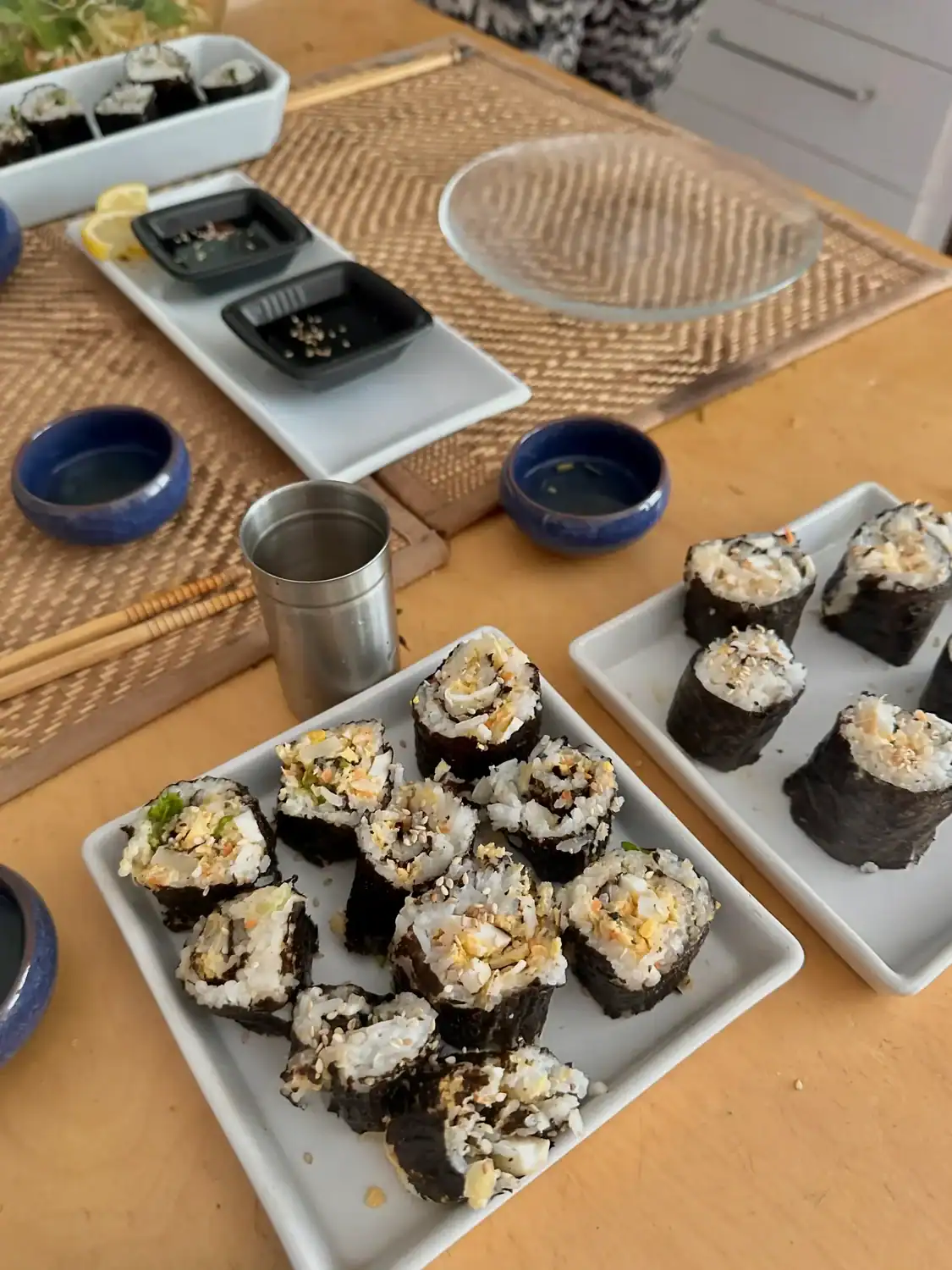 Homemade sushi rolls arranged on plates during a shared meal and cooking session.
