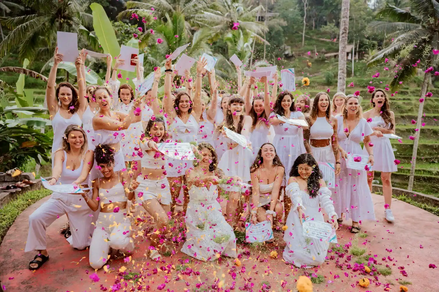 House of Om 200-hour yoga teacher training Bali graduates celebrating with certificates and flower petals in Ubud