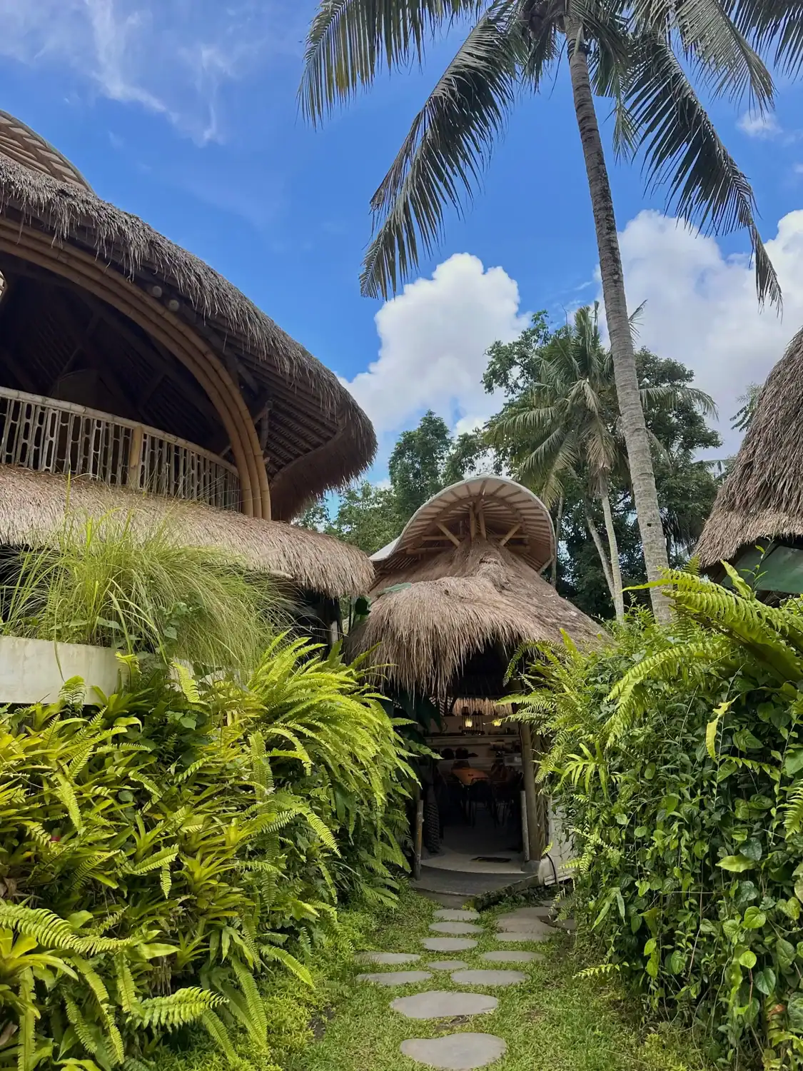 Bamboo eco-village pathway and thatched roof structures at SKY Yoga and Meditation yoga teacher training in Bali