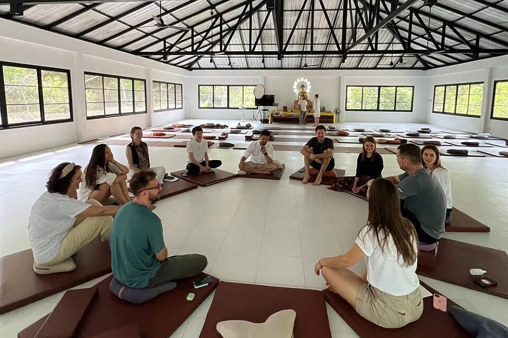 Guests sitting on cushions in a large meditation hall during a Vipassana retreat on Koh Phangan